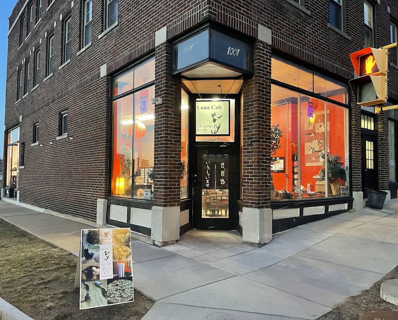 Corner brick storefront of Luna Cafe with glowing interior at dusk